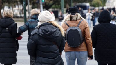 Άνθρωποι περπατούν στο κέντρο της Αθήνας με χειμωνιάτικα ρούχα